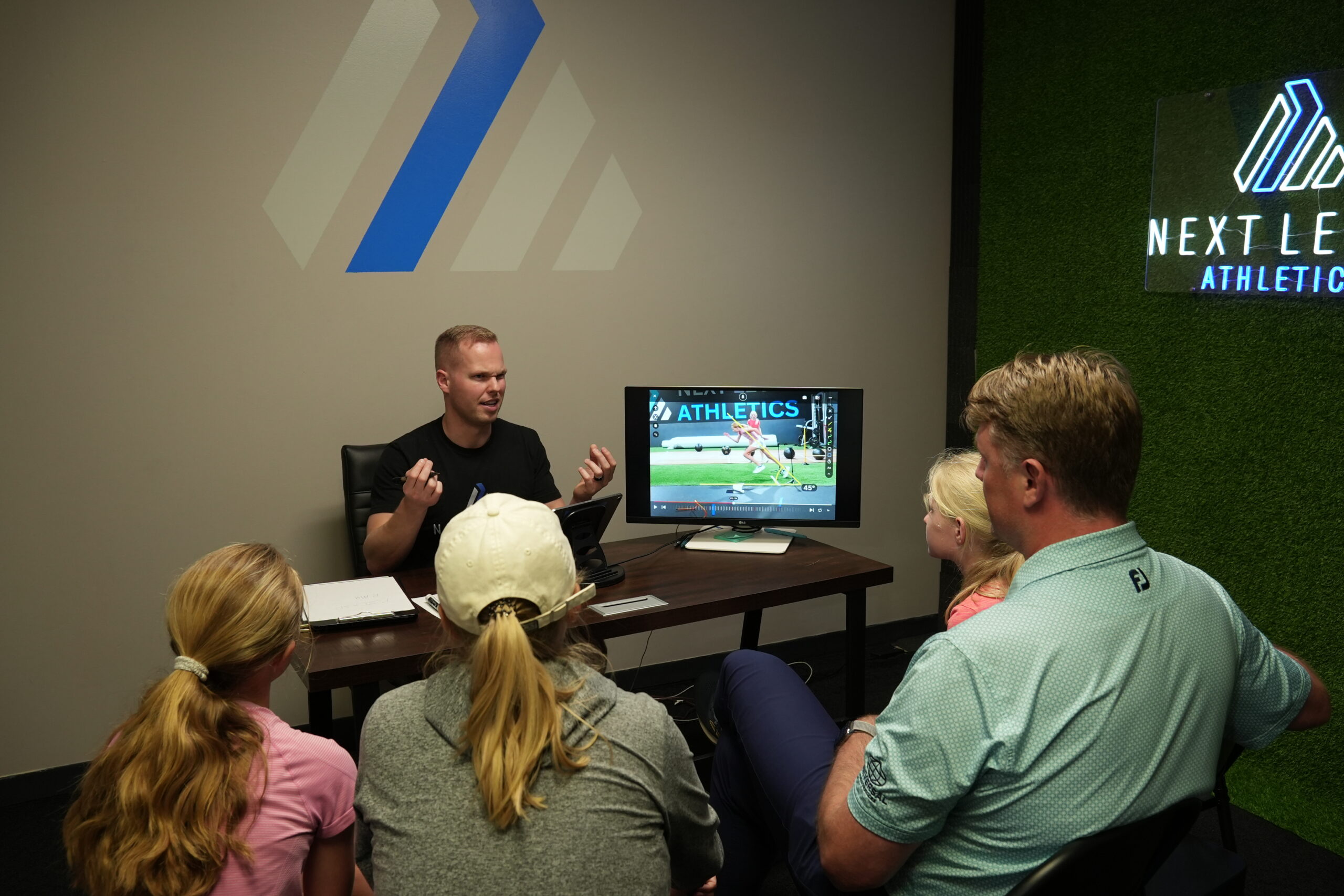 Josh, NLA's head trainer, walks a family through their athlete's CoachNow footage frame-by-frame during the Movement Analysis review